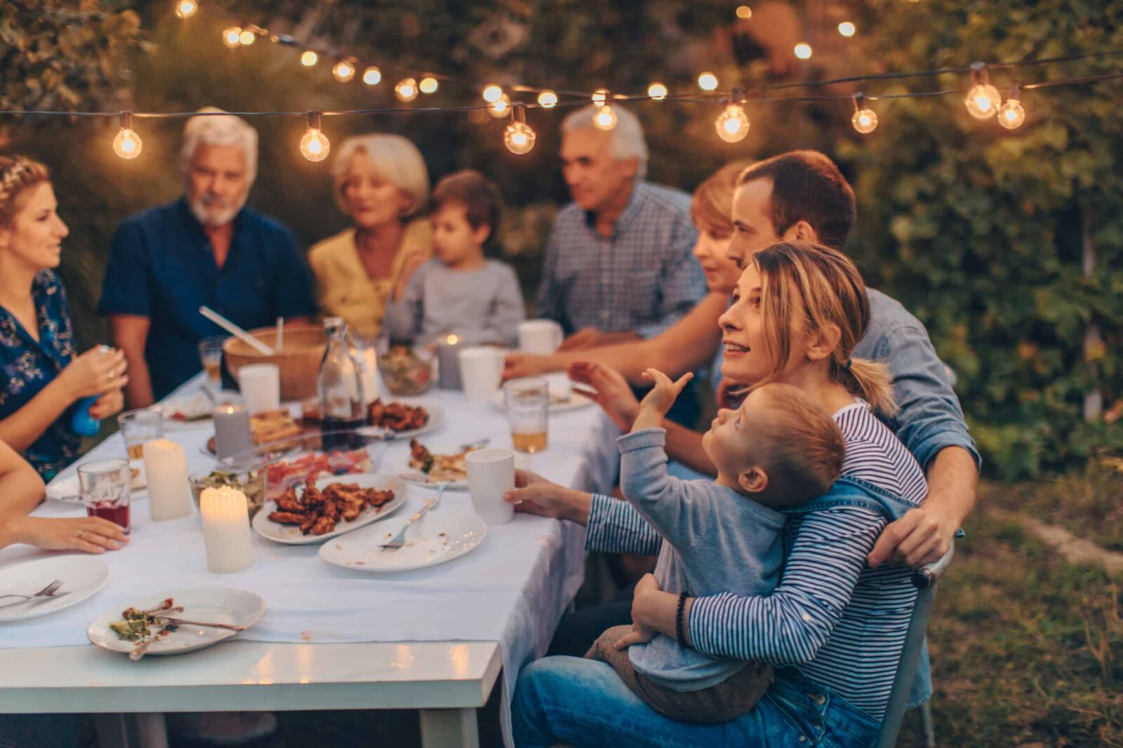 Photo of a big family during Thanksgiving dinner, celebrating holiday together in the backyard