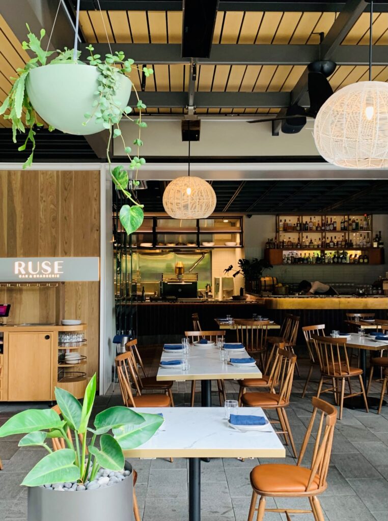 Empty restaurant and bar with stylish lighting and pot plants and electric heaters