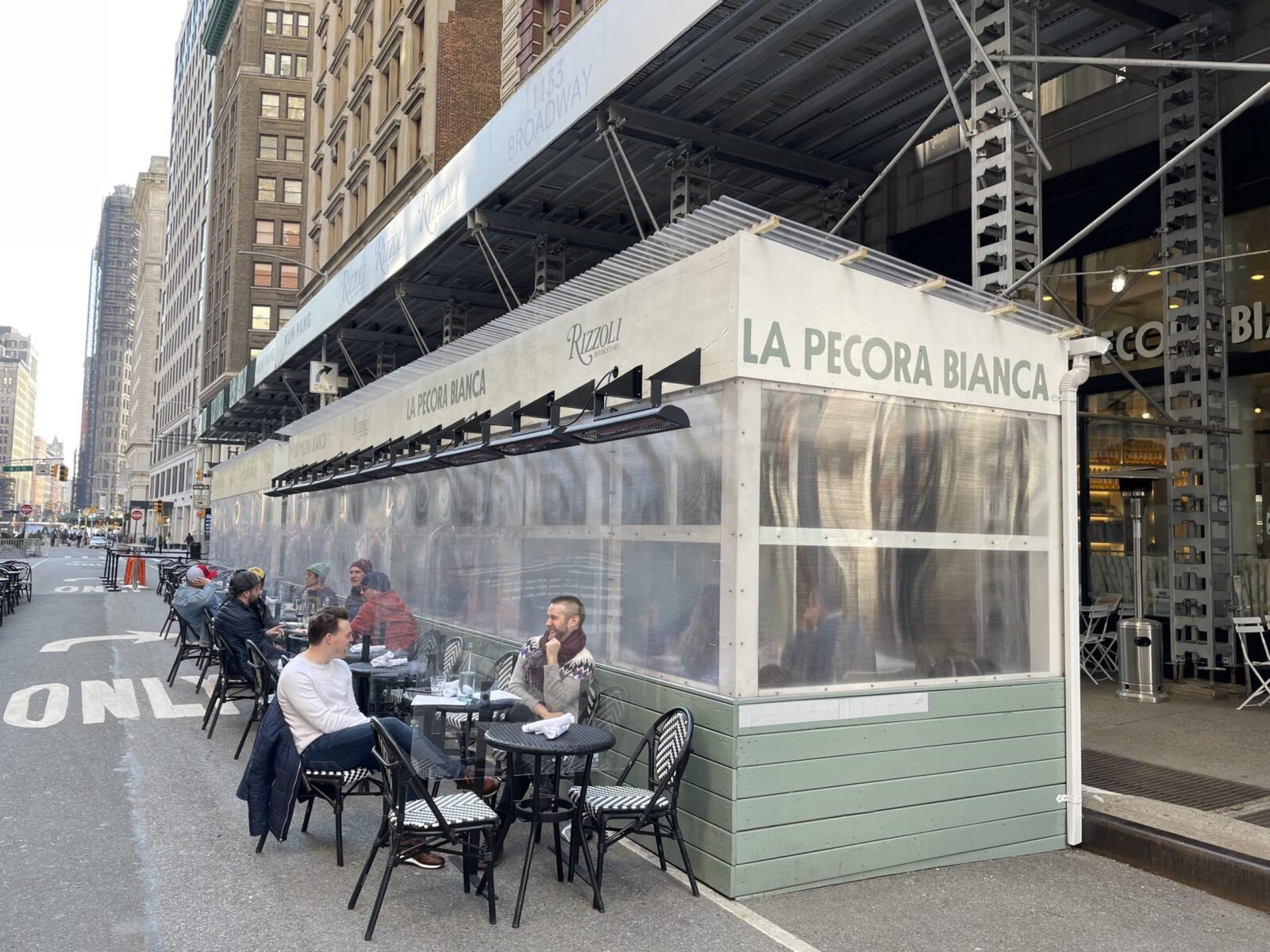 Les sièges d'un restaurant s'étalent sur la route à New York avec des chauffages électriques.