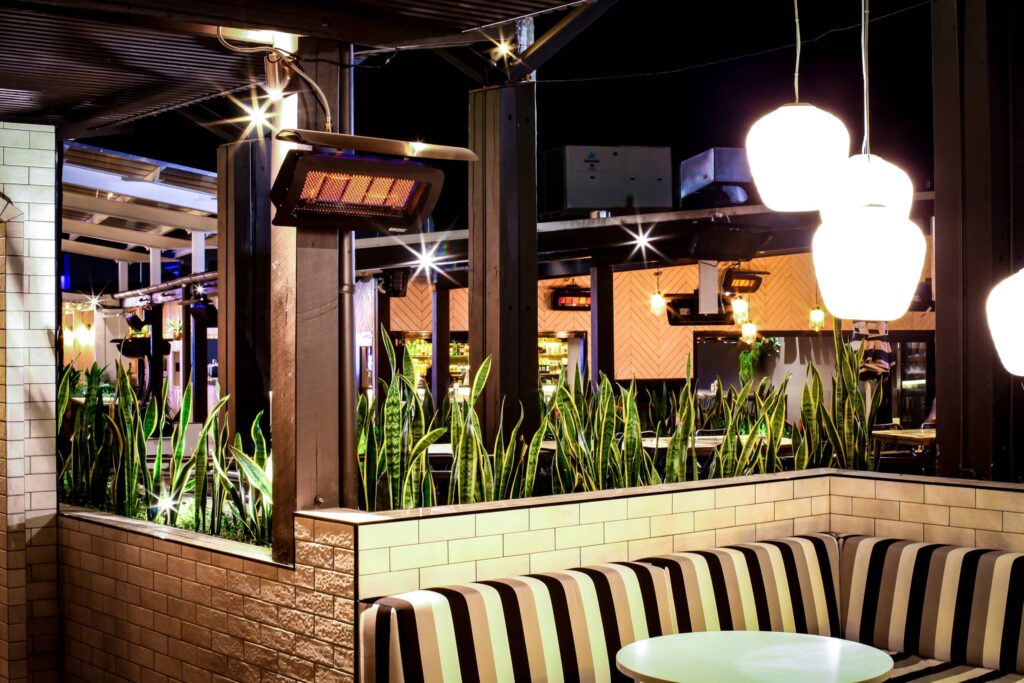 Single Booth Seating in Restaurant with decorative plant life and electric heaters