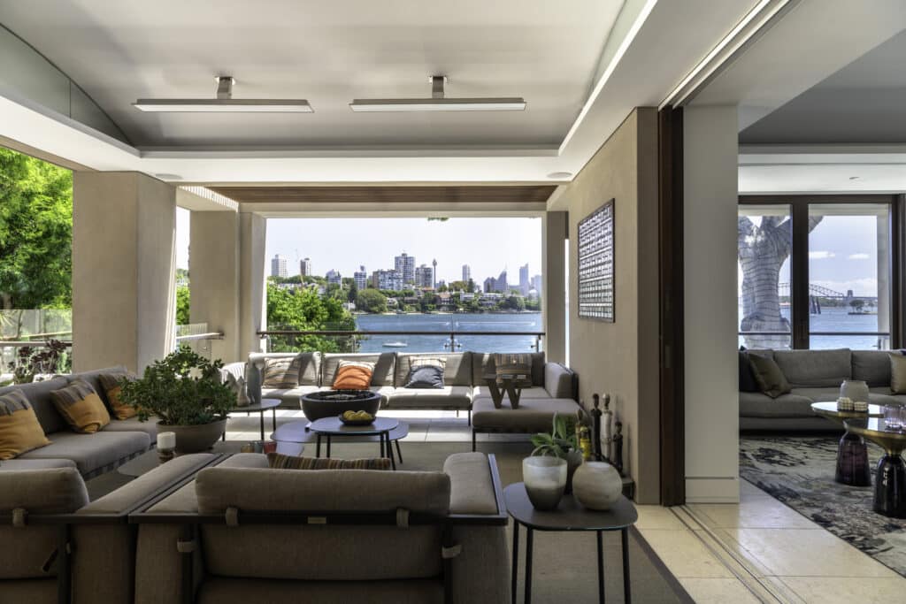 Salon extérieur avec vue sur l'horizon et le port de Sydney, équipé de chauffages électriques.